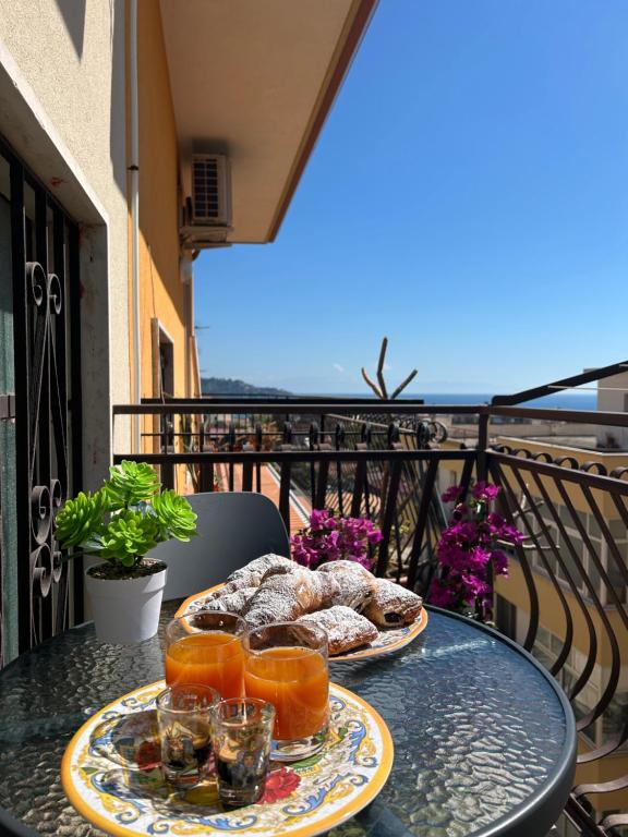 two plates of food sitting on a table on a balcony at Casa Puglia in Giardini Naxos
