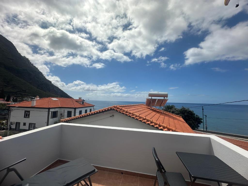 a balcony with chairs and a view of the ocean at Gori House in Madalena do Mar