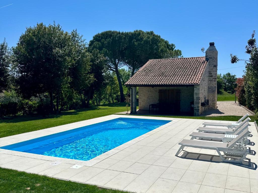 a swimming pool with two lounge chairs and a building at Villa Ondina - private pool in Brtonigla