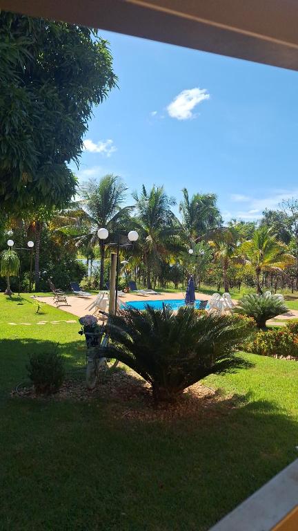 Una vista de una piscina desde la ventana de un resort. en Recanto famila lago das brisas, en Corumbazul