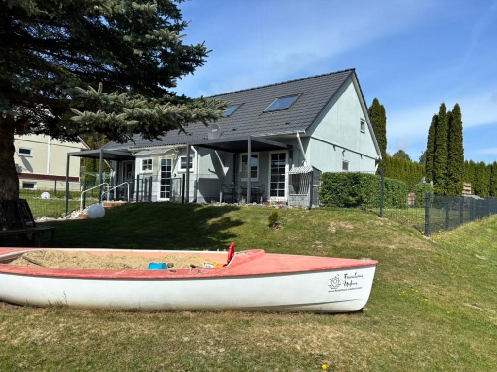 a boat sitting on the grass in front of a house at Ostsee Ferienhaus Usedom hundefreundlich Familie Stopp Haus 22 in Lütow