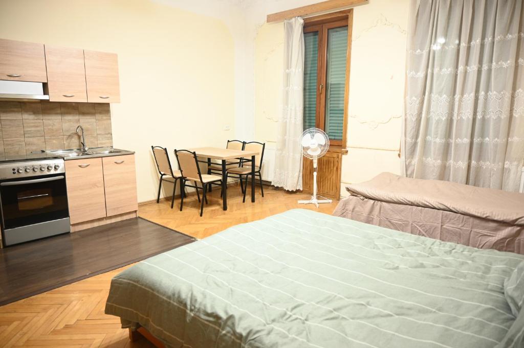 una camera con letto e una cucina con tavolo di Long Tree Hostel - Comfy Mattress a Tbilisi City