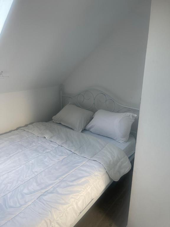 un lit blanc avec des draps et des oreillers blancs dans l'établissement CMJJ Hope 2etage, à Calais