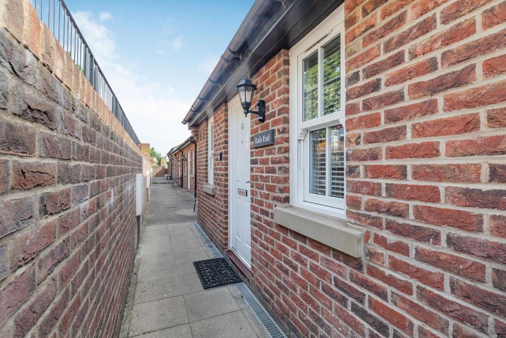 a brick alley with a window on a brick building at Rails End in Whitby