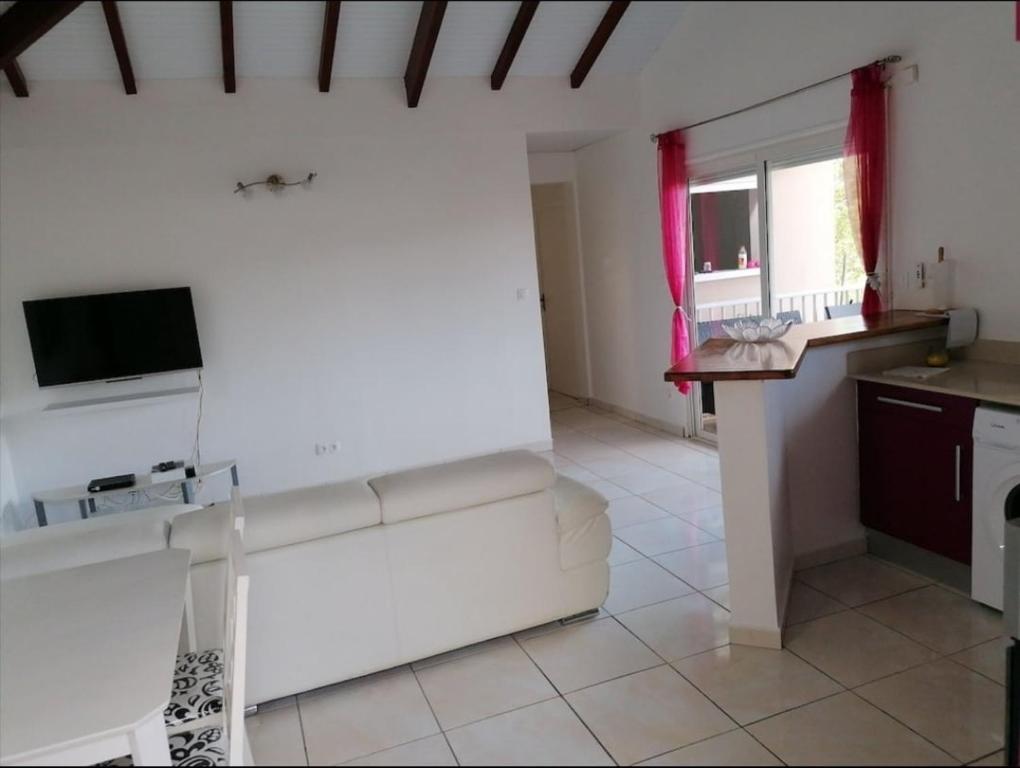 Una sala de estar con un sofá blanco y una mesa. en Villa Bien-Désiré, en Saint-François