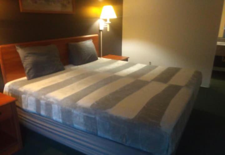 a large bed in a bedroom with a lamp at 2 Double Beds Hotel Studio 134 in Livingston