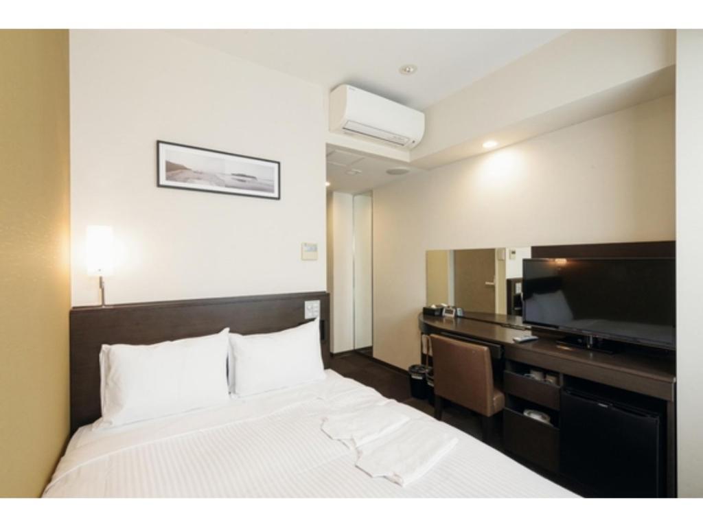 a hotel room with a bed and a flat screen tv at Kipp Hotel Shonan Fujisawa - Vacation STAY 05488v in Fujisawa