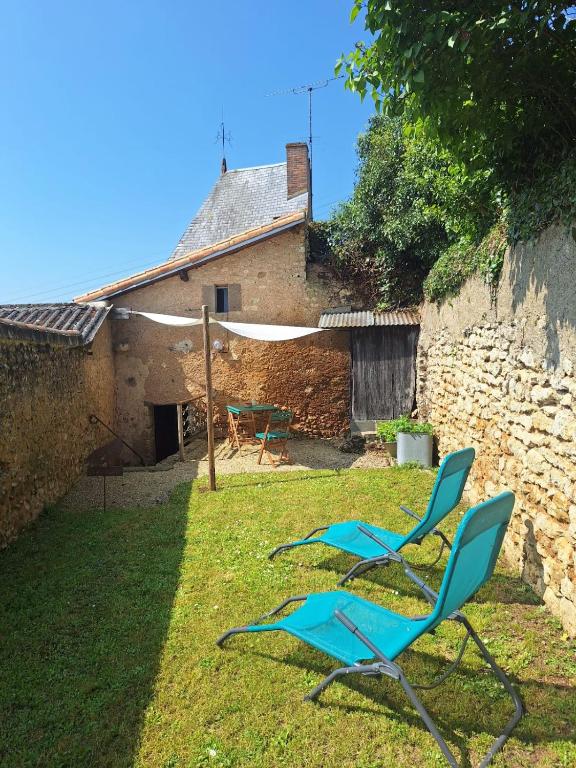 deux chaises bleues assises dans l'herbe dans une cour dans l'établissement La maison du Donjon, à Airvault
