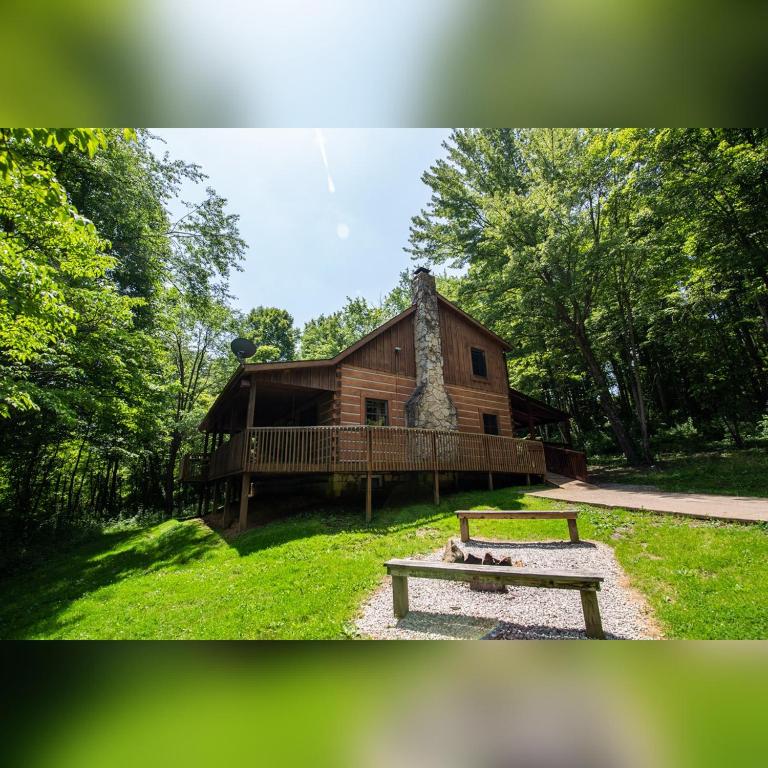 a log cabin with a bench in front of it at Dogwood - by The Chalets in Logan