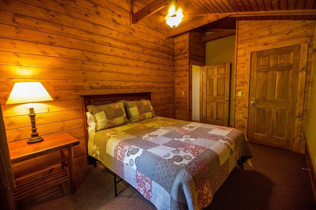 a bedroom with a bed in a wooden cabin at Dogwood - by The Chalets in Logan