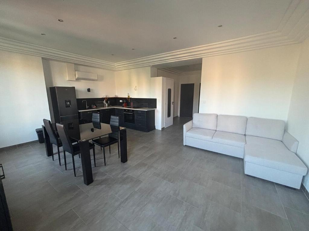 un salon avec un canapé blanc et une table dans l'établissement 3-R bright, beach within 15 min walk, à Nice