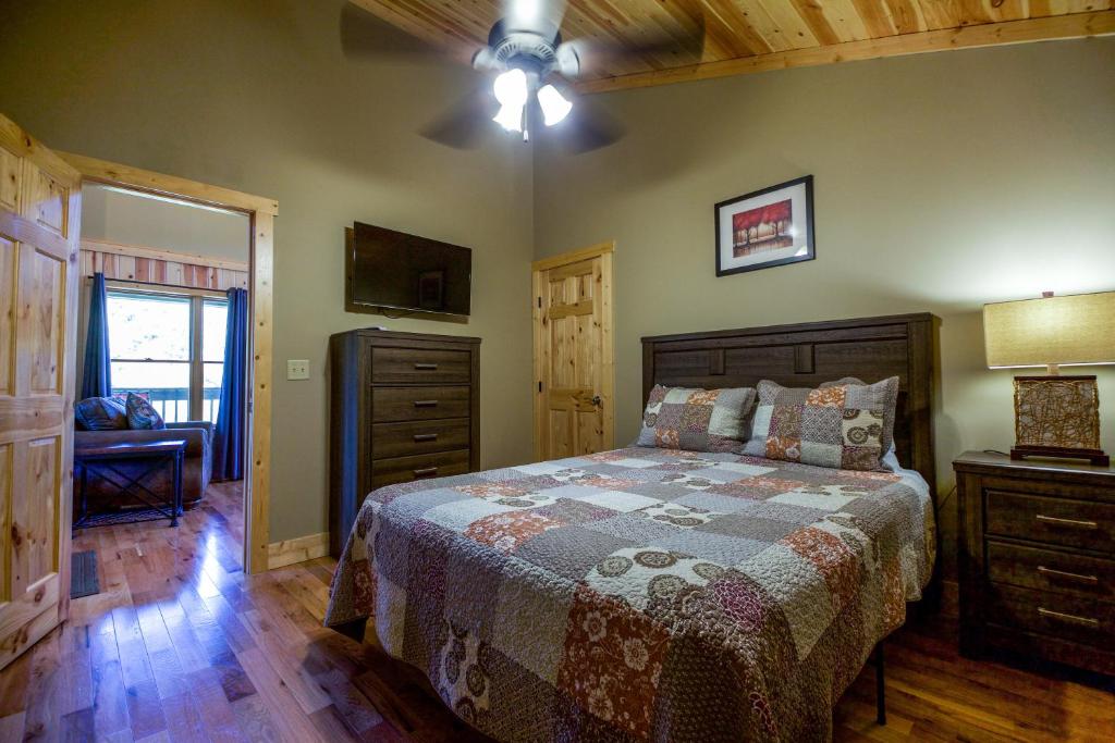a bedroom with a bed and a dresser and a window at Overlook - by The Chalets in Logan