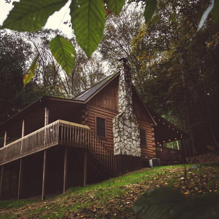 a log cabin on a hill with a fence at Pine Creek - by The Chalets in South Bloomingville