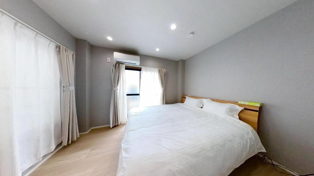 a bedroom with a white bed and a window at Hotel Yado SK Shinkoiwa - Vacation STAY 17432v in Tokyo