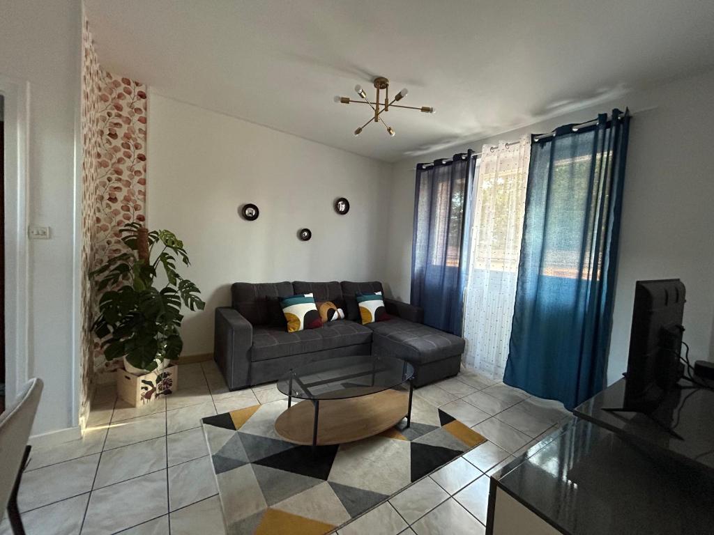 a living room with a couch and a table at Home Lyla in Dijon