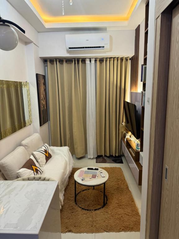 uma sala de estar com um sofá e uma mesa em Field Residence Cozy Condo In Paranaque em Manilla