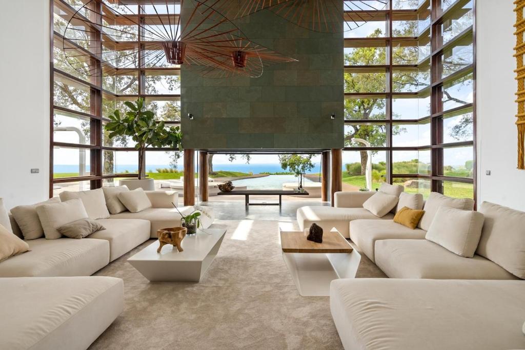 a living room with white furniture and large windows at luxury 4 bedroom villa in Benalmádena