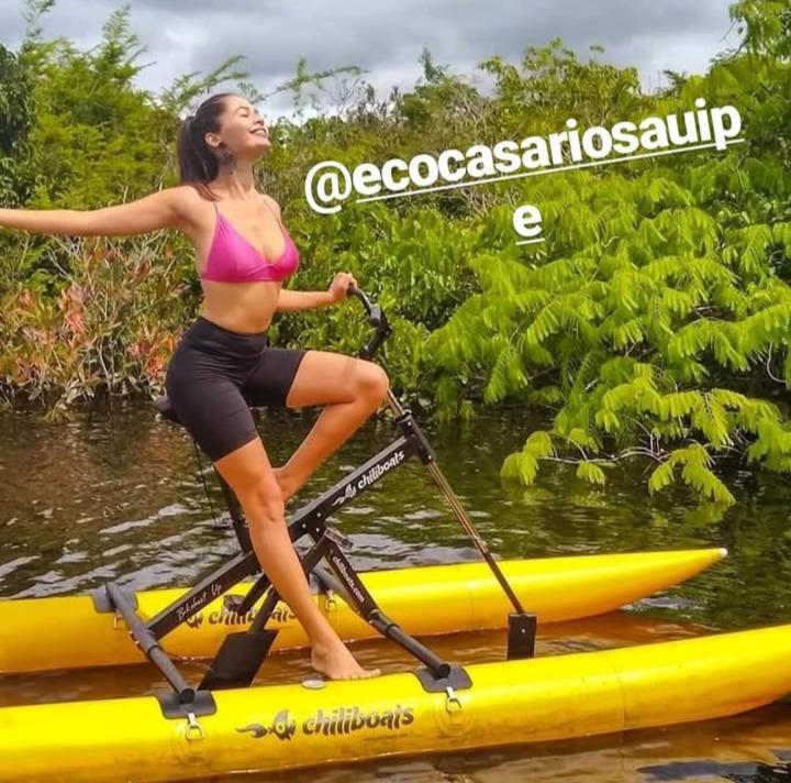 a woman in a bikini on a paddle board at EcoCasa Rio Sauípe 200 m da Praia in Porto de Sauipe