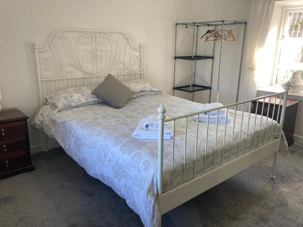 a bedroom with a white bed with a head board at Annie's Cottage On The Corner in Donegal