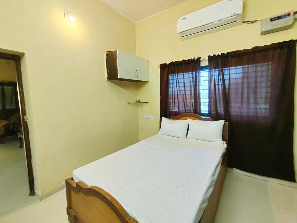 a bedroom with a bed with white sheets and a window at The Heaven - Farms & Resorts in Ānakhol