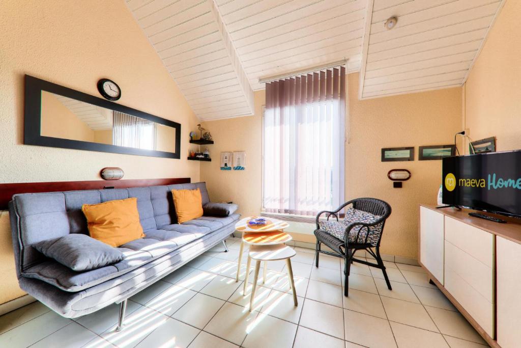un salon avec un canapé et une télévision dans l'établissement Résidence Port du Crouesty - maeva Home - Appartement duplex bord de mer 3 pièces 5 personnes - Confort MAE-2221, à Arzon
