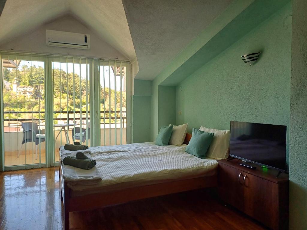una camera da letto con un letto e una TV a schermo piatto di Heaven Apartment a Ohrid