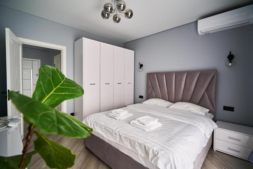 Un dormitorio con una cama grande con sábanas blancas. en Full-Equipped 1BR in Center by Torro Mall, en Chişinău