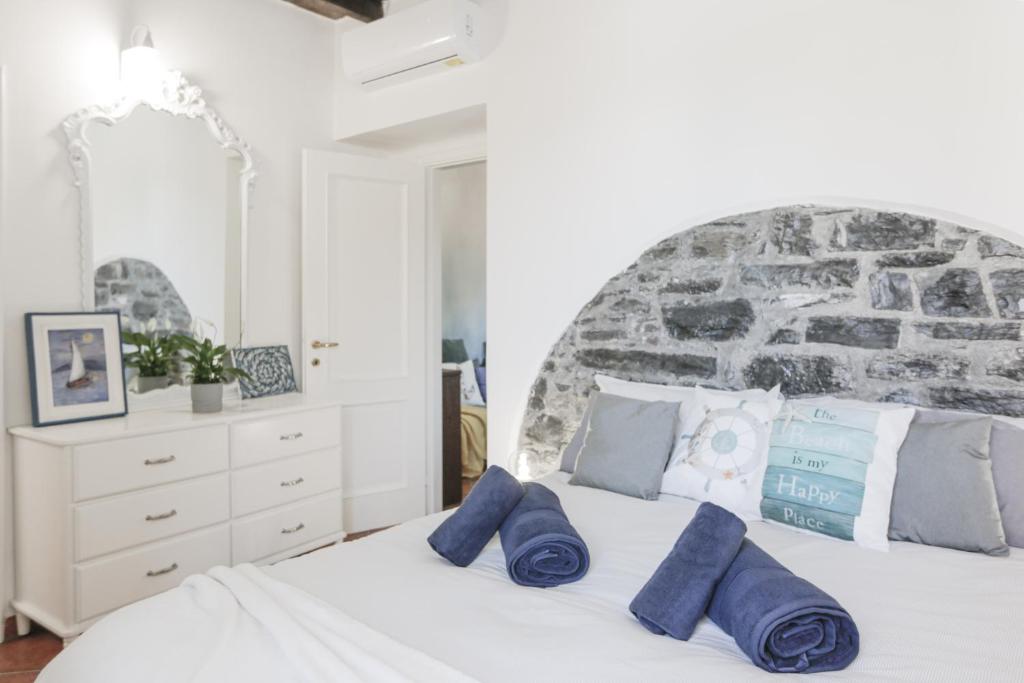 a bedroom with a large white bed with blue pillows at In the Historic Village - Riva Lago 10 in Carate Urio