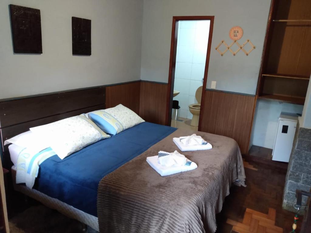 a bedroom with a bed with towels on it at Chalé vista do jardim 9 in Itatiaia