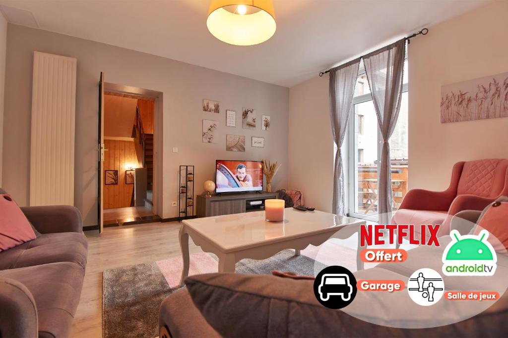 a living room with a table and a tv at Maison LAMARTINE - Plein Centre-Ville Avec Garage & Jeux in Saint-Claude