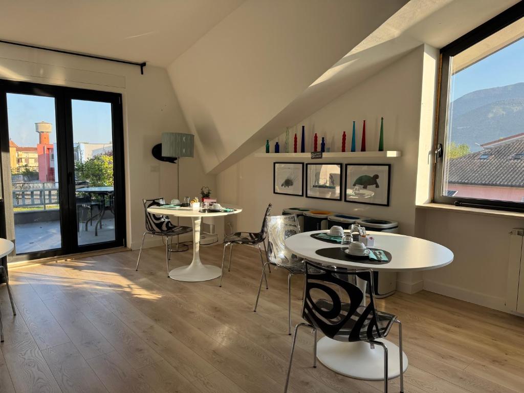 two tables and chairs in a room with windows at Villa Angelina in Aquino