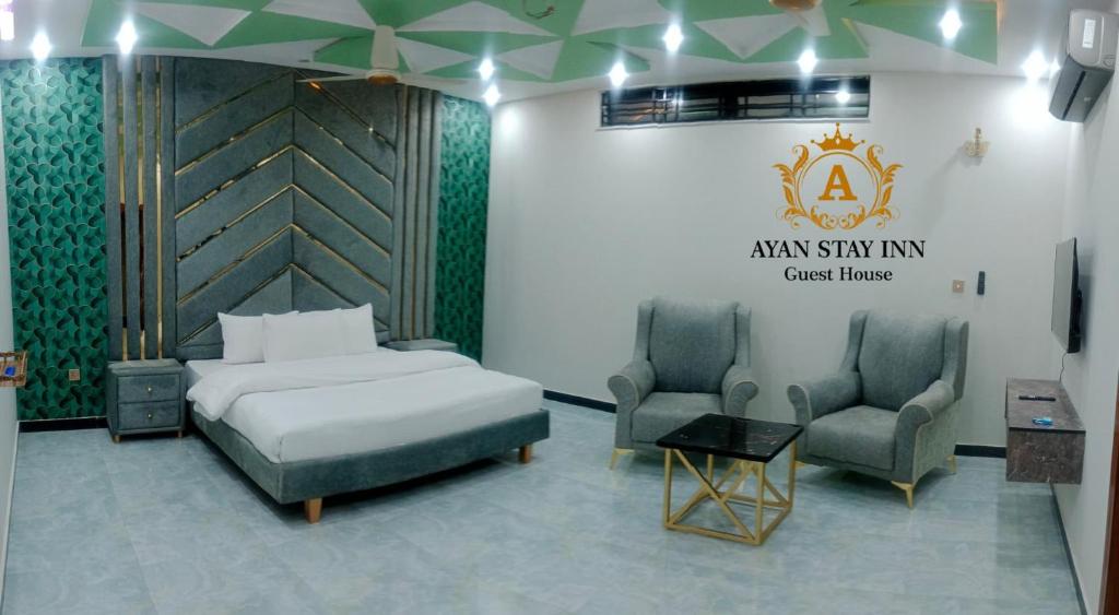 a hotel room with a bed and two chairs at Ayan stay inn in Dargai