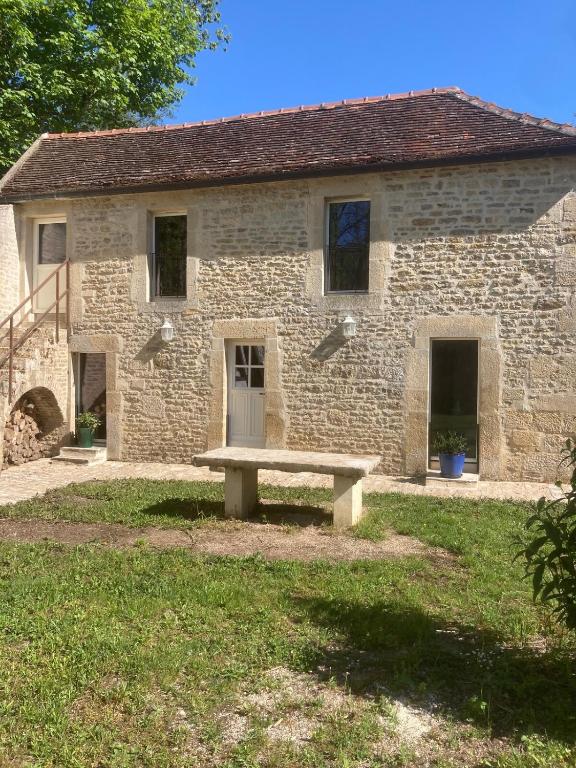 un bâtiment en pierre avec un banc devant lui dans l'établissement La petite Chapelle, à LʼIsle-sur-Serein