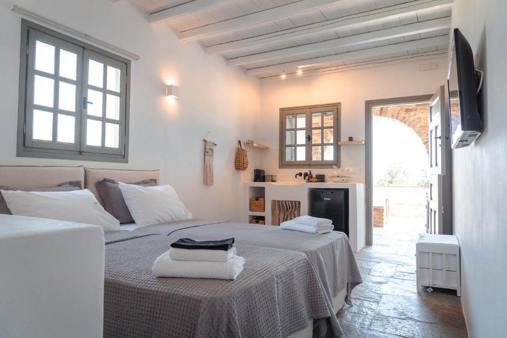 a white room with two beds and a kitchen at Living Blue Tinos in Kardhianí