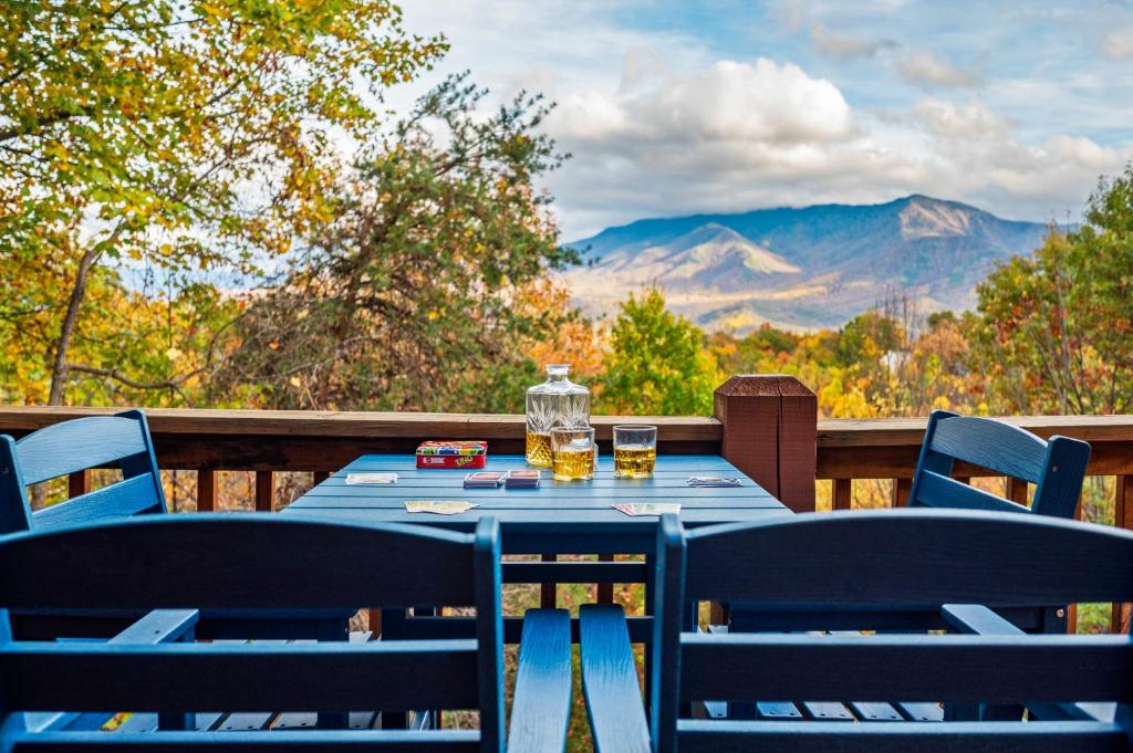 a blue table with two chairs and a view of mountains at Mtn Views, Hot Tub, Sauna, EV, Arcade! in Gatlinburg