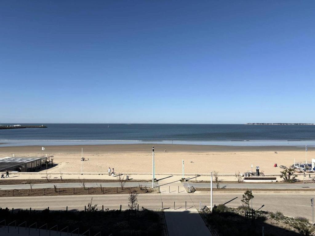 une plage de sable avec l'océan en arrière-plan dans l'établissement Résidence Les Océanes - Location de Vacances - PORNICHET - Studio cabine - Face Mer MAE-0651, à Pornichet