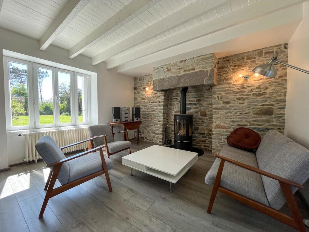 - un salon avec un canapé, des chaises et une cheminée dans l'établissement Gîte à proximité de la plage du Rozel et du GR 223, à Le Rozel