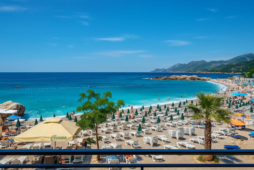 una spiaggia con sedie e ombrelloni e l'oceano di Apartments Lejla a Dobra Voda