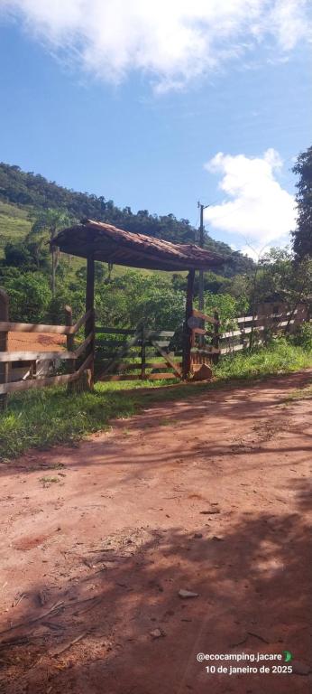 a wooden pavilion on the side of a dirt road at EcoCamping Jacaré in Baependi