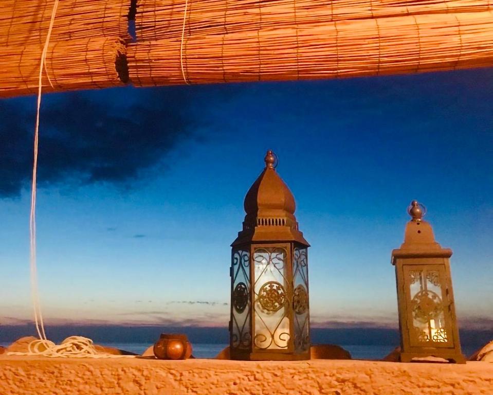 two clocks are sitting on top of a building at Luxury Sea View Apartment 100 mt Mare in Costa Paradiso