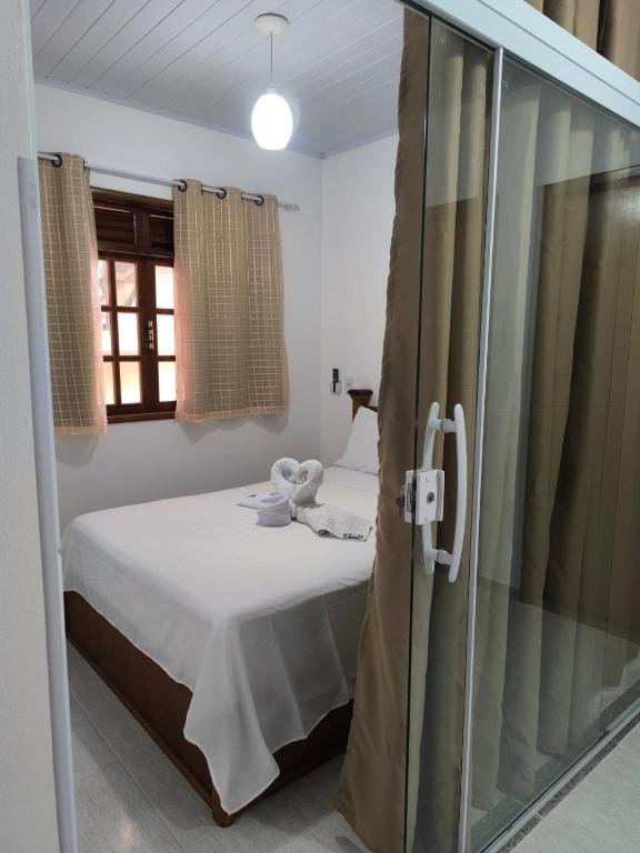 a bedroom with a bed and a glass shower at Casa Zago 2 in Santa Maria Madalena