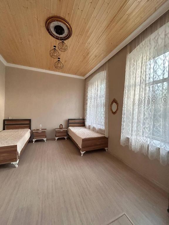 a large room with two beds and a window at Shaki Best house in Sheki