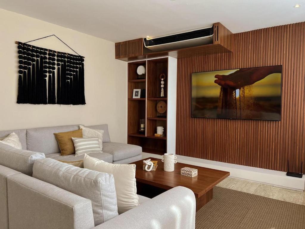 a living room with a couch and a table at Penthouse Om in Tulum