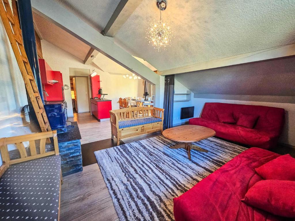 un salon avec un canapé rouge et une table dans l'établissement Résidence Eperviere - Appartement au pied des pistes de 3 pièces, 6 à 8 personnes MAE-6931, à Saint-Martin-de-Belleville