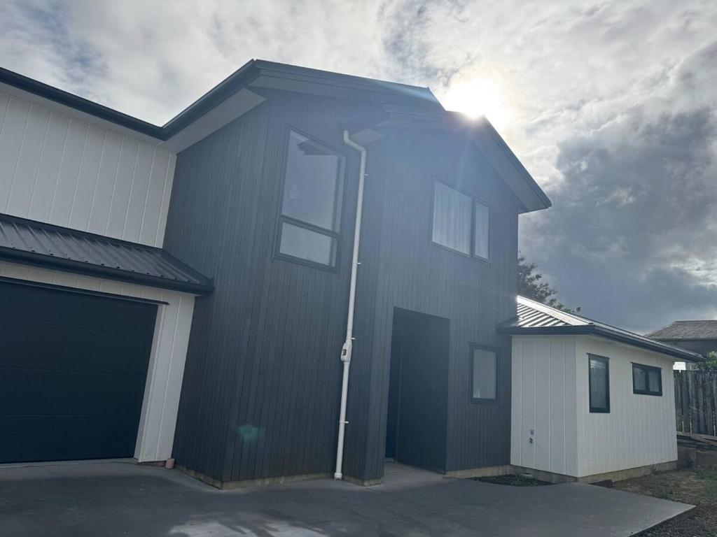 RiverheadにあるBrand-new Family Retreat in Riverhead 4BR Homeのガレージがあり、太陽が輝く家