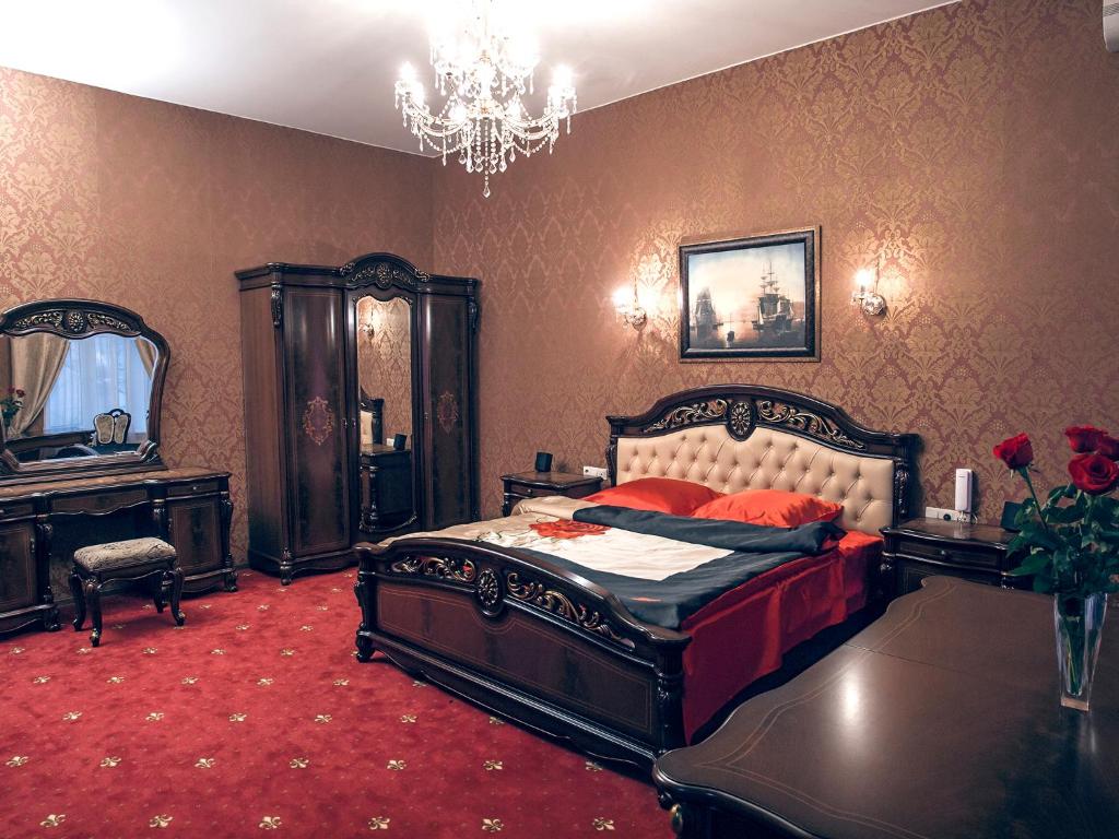 a bedroom with a bed and a mirror and a chandelier at Piter Hotels in Saint Petersburg