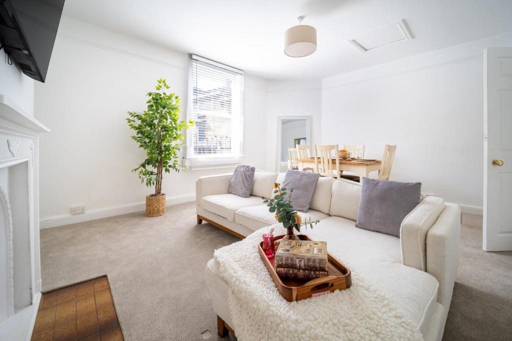 a living room with a white couch and a table at Larkhall Retreat- Village Centre, Parking, 4K TVs, 10mins To City Centre in Bath