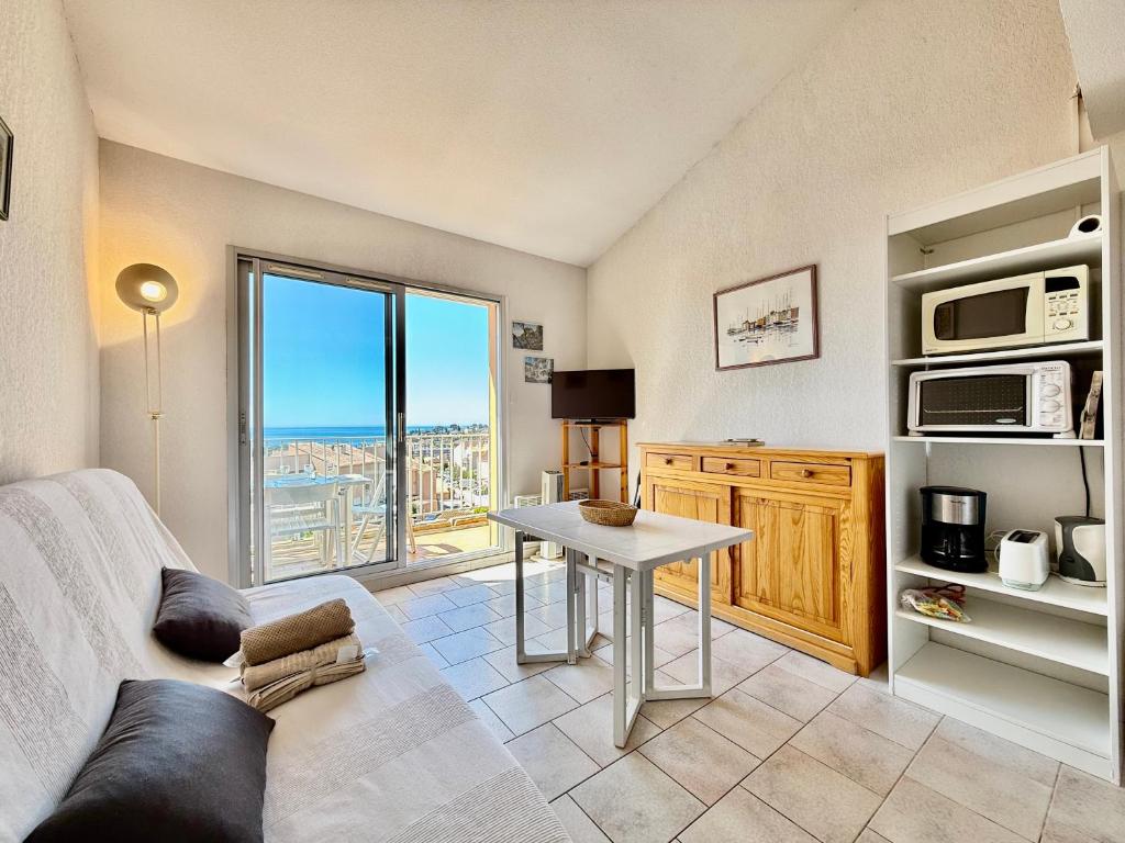 un salon avec un canapé et une table dans l'établissement Duplex - Piscine - Terrasse Vue Mer, à Carqueiranne