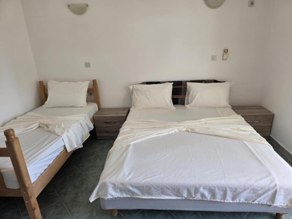 two beds in a room with white sheets and pillows at SHARRI Apartments in Ulcinj