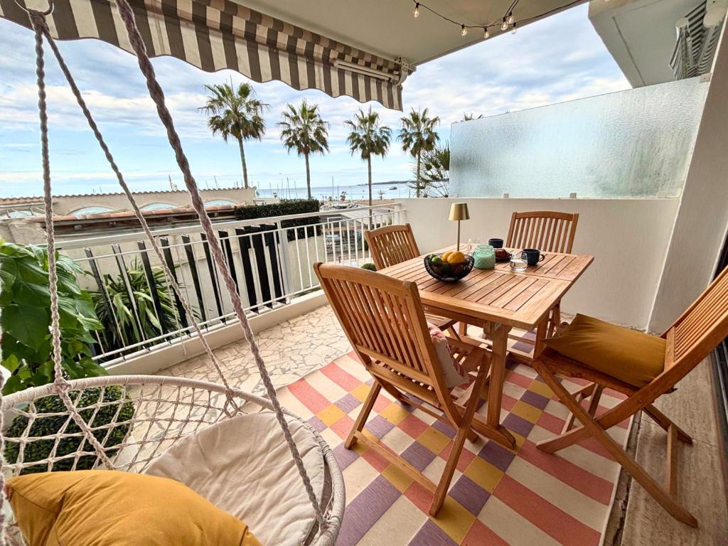 - un balcon avec une table et des chaises en bois dans l'établissement Etoile du Cap - Beach Front 2 BDR Partial Sea View, à Cannes